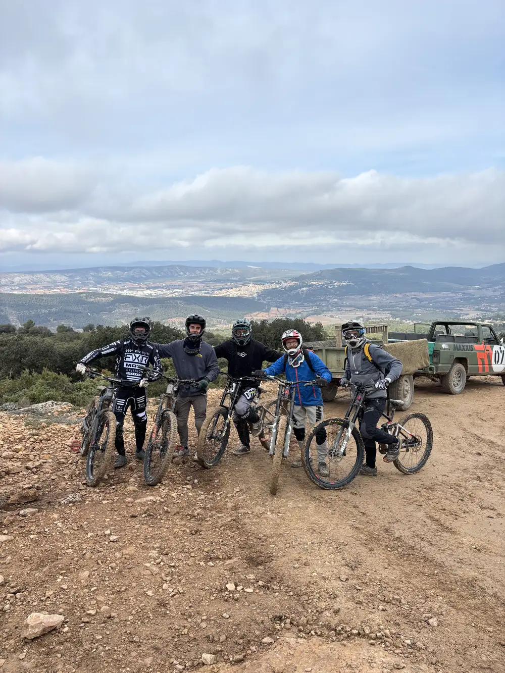 Grupo de riders con furgón de apoyo en pista de tierra